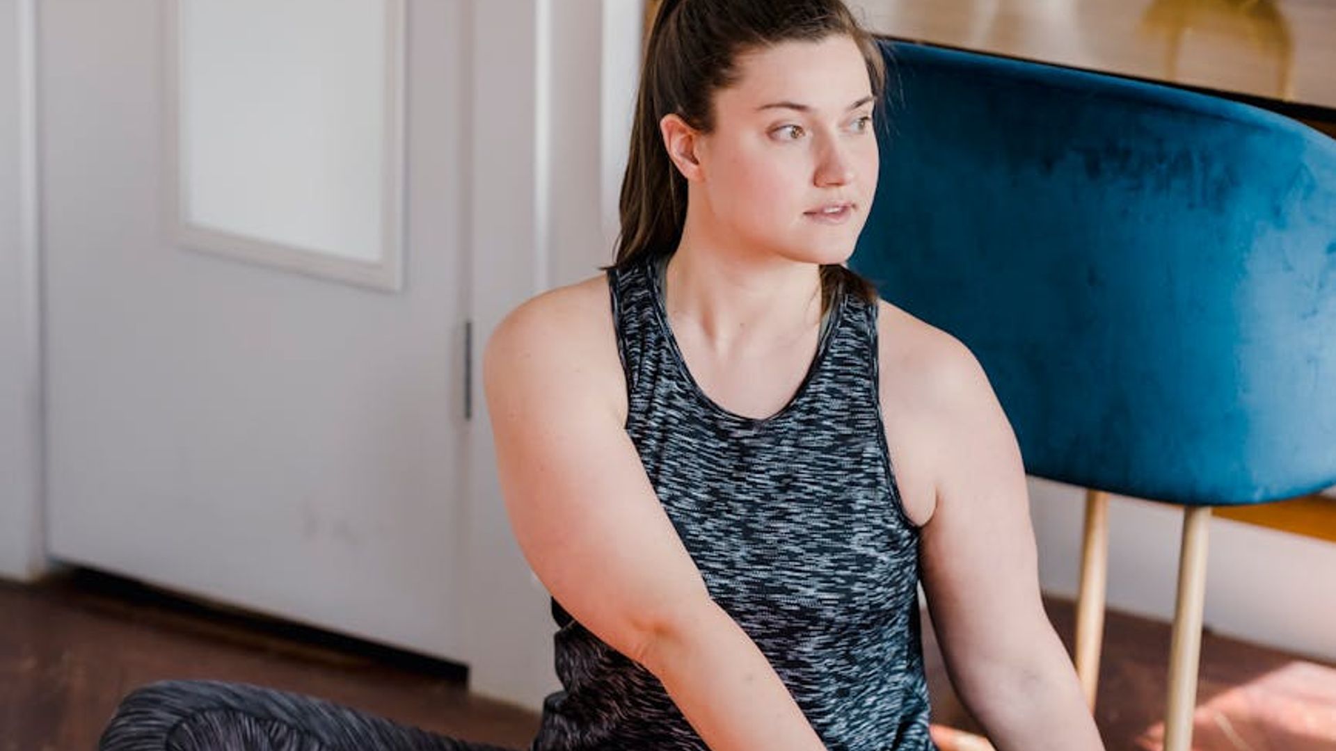 Calm and focused woman in a yoga posture in a dark room.